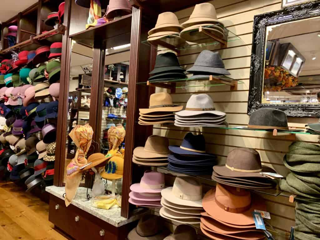 The inside of the hat shop with hats arranged along a wall.