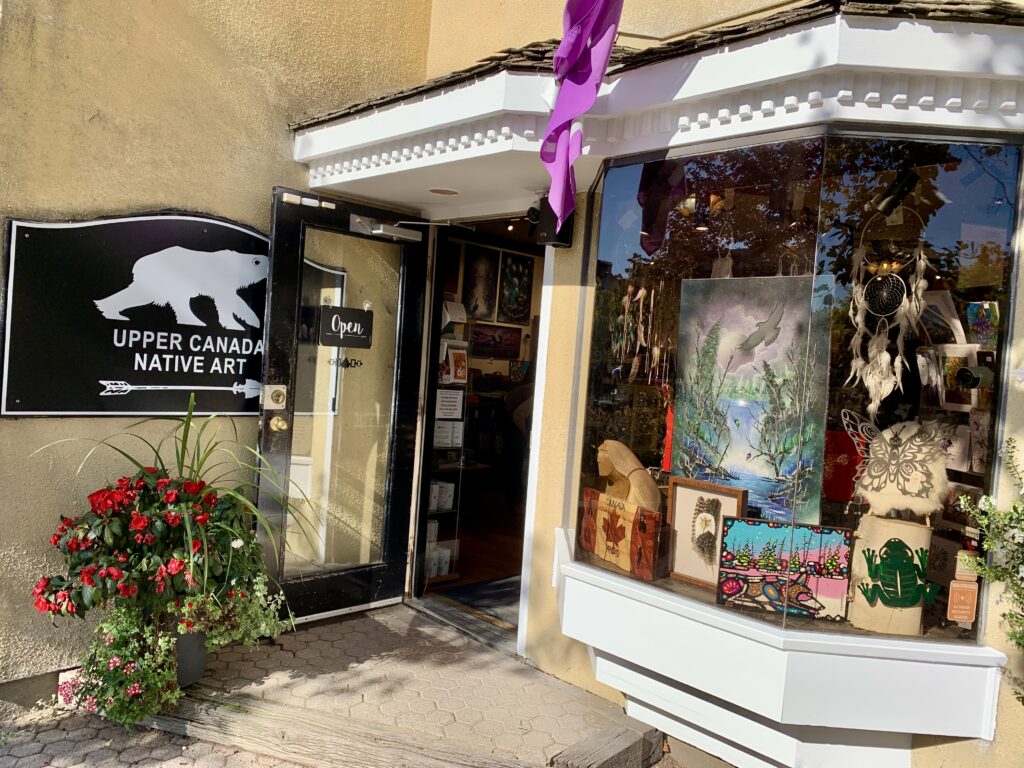 The front of the store. Yellow building with white trim welcomes you with a black sign with white lettering and a white polar bear.