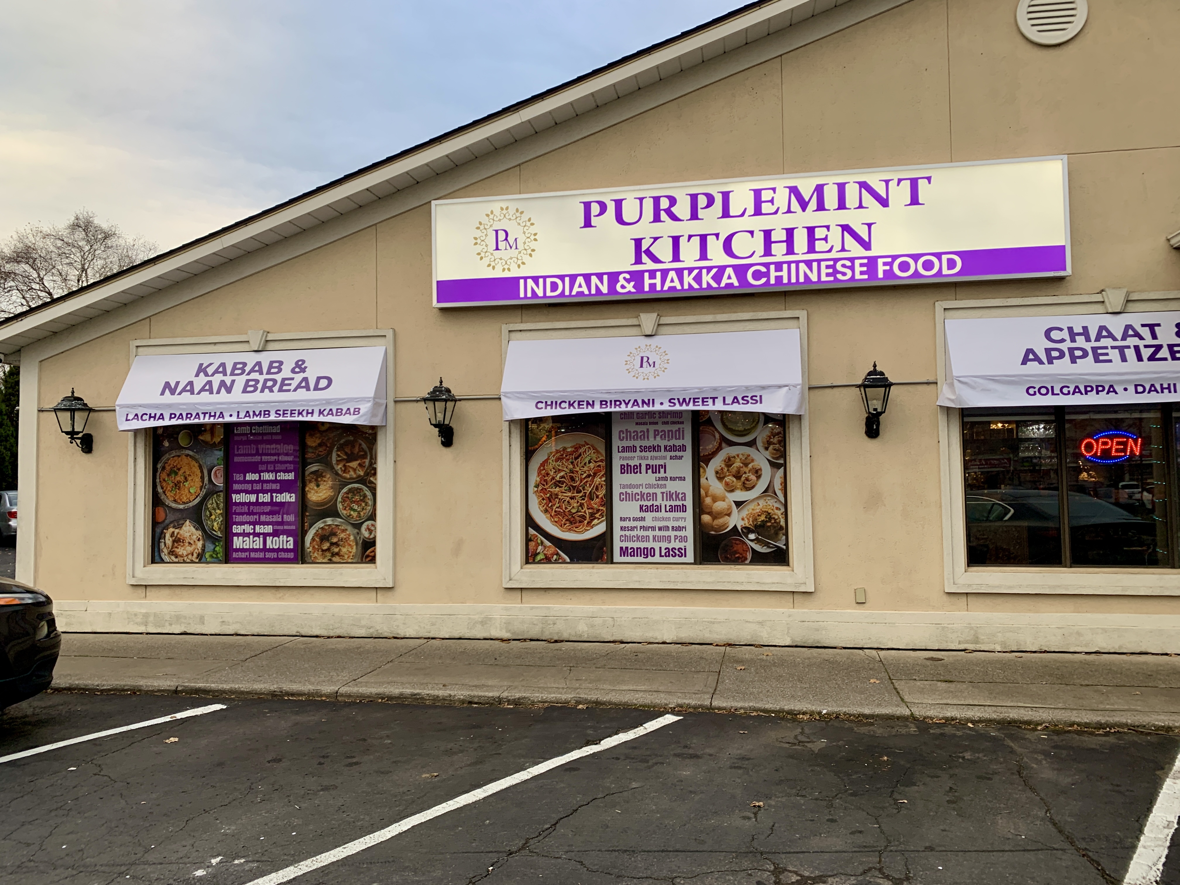 The exterior of Purplemint Kitchen is beige with some branding and advertising in the windows.