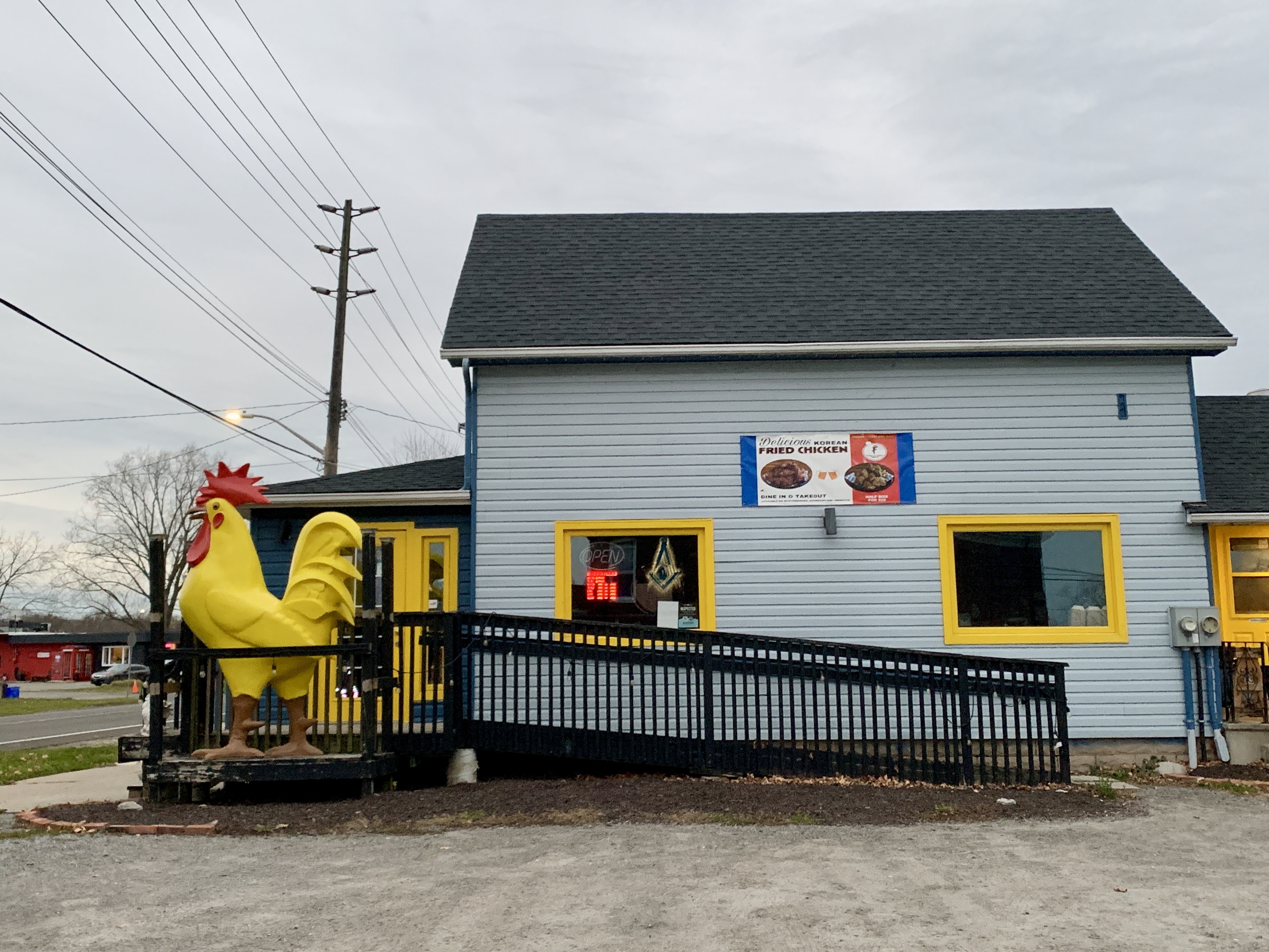 ROK's Korean fried chicken is a blue and yellow building with a large yellow chicken statue in front. It is a hidden gem restaurant in Niagara Falls.