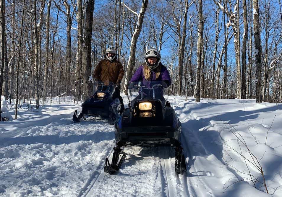 Two people on small snowmobiles in Muskoka